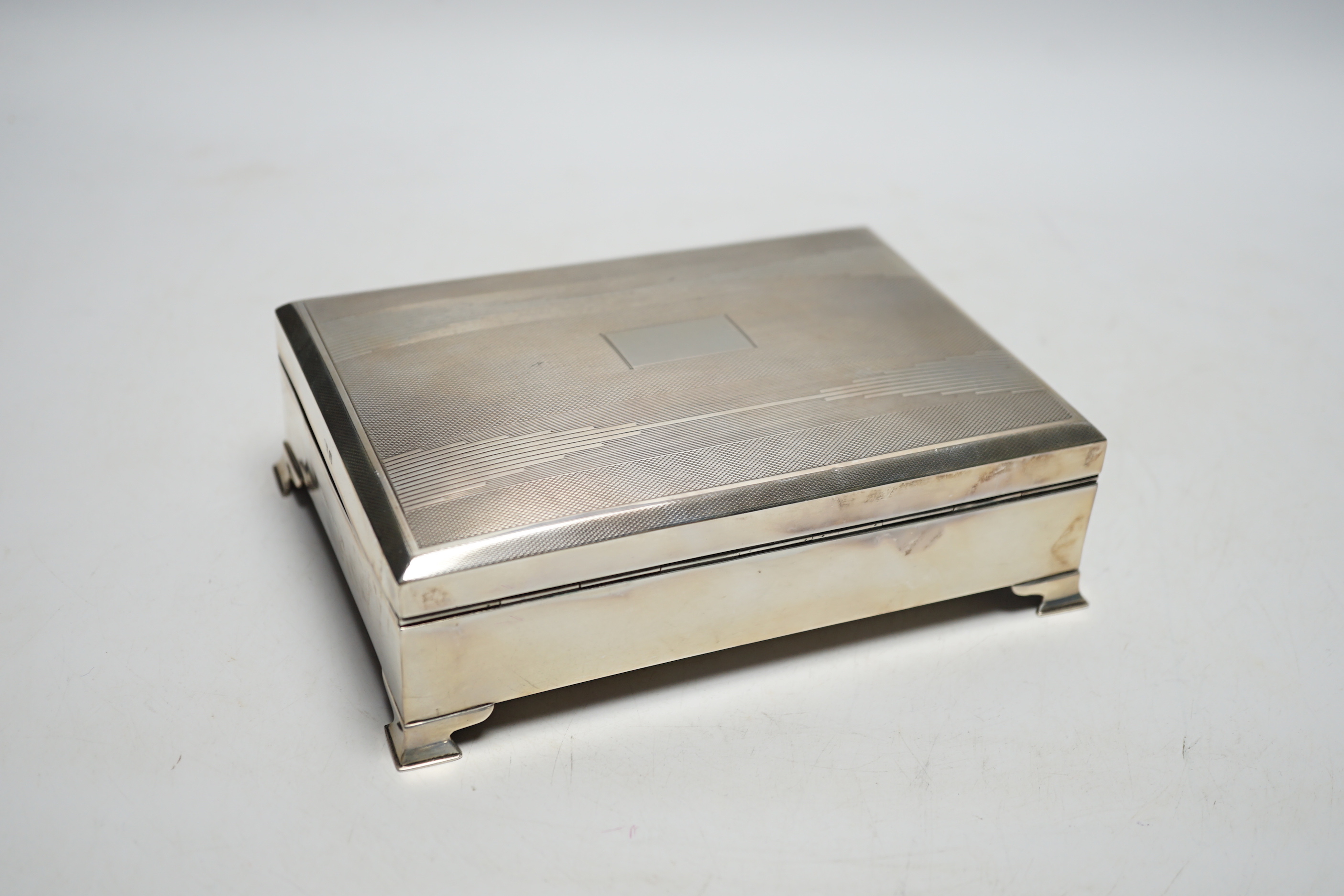 An Art Deco part engine turned silver rectangular cigarette box, Birmingham, 1937, 16.9cm.